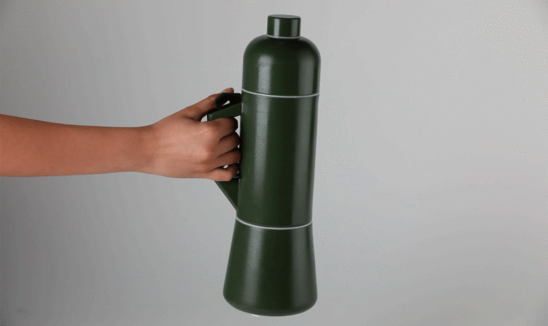A hand holding a green water bottle by the handle