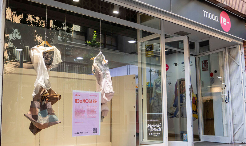 Shop window displaying two fashionable looks created with upcycling, shown from the side.