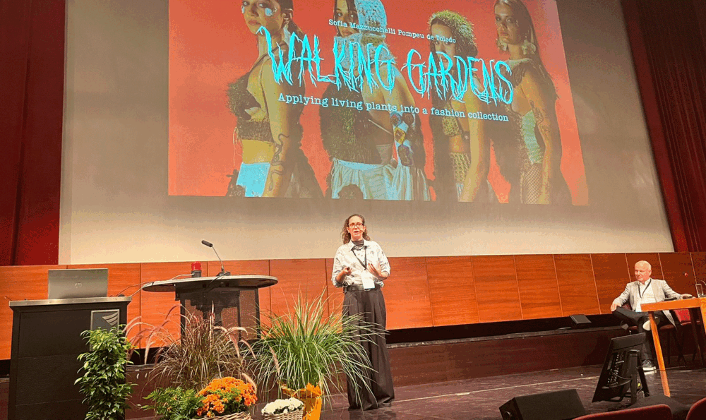 A woman at center stage in an auditorium receiving an award.
