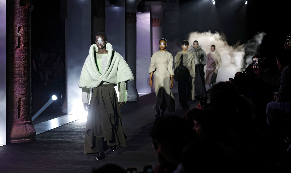 Models walking down a dark, smoky fashion runway