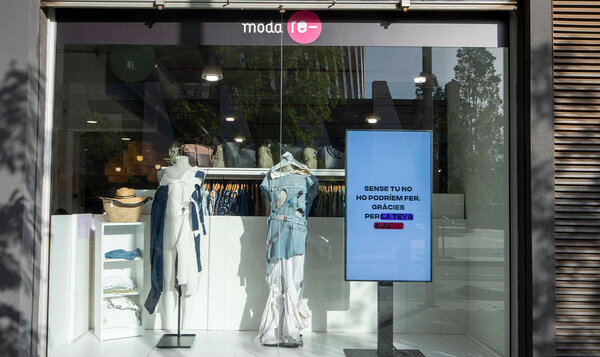 Shop window displaying two fashionable looks created with upcycling